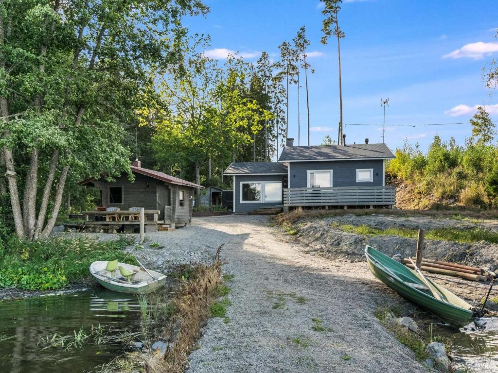 une maison avec deux bateaux sur la rive d'un lac dans l'établissement Holiday Home Hiekkalahti by Interhome, à Sastamala