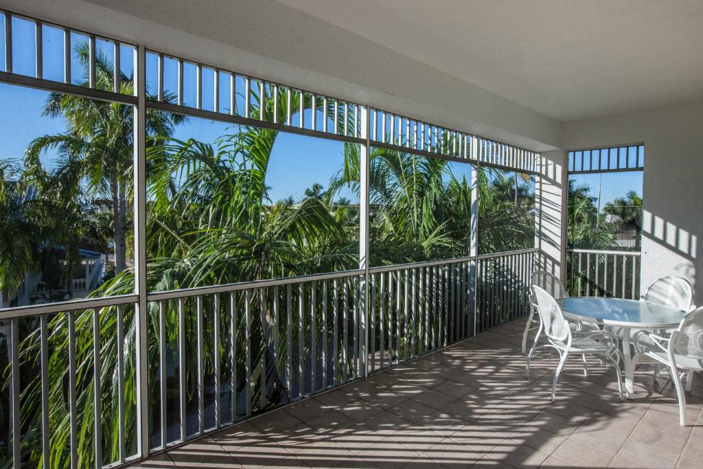 a balcony with a table and chairs and palm trees at Olde Marco Island Inn and Suites in Marco Island