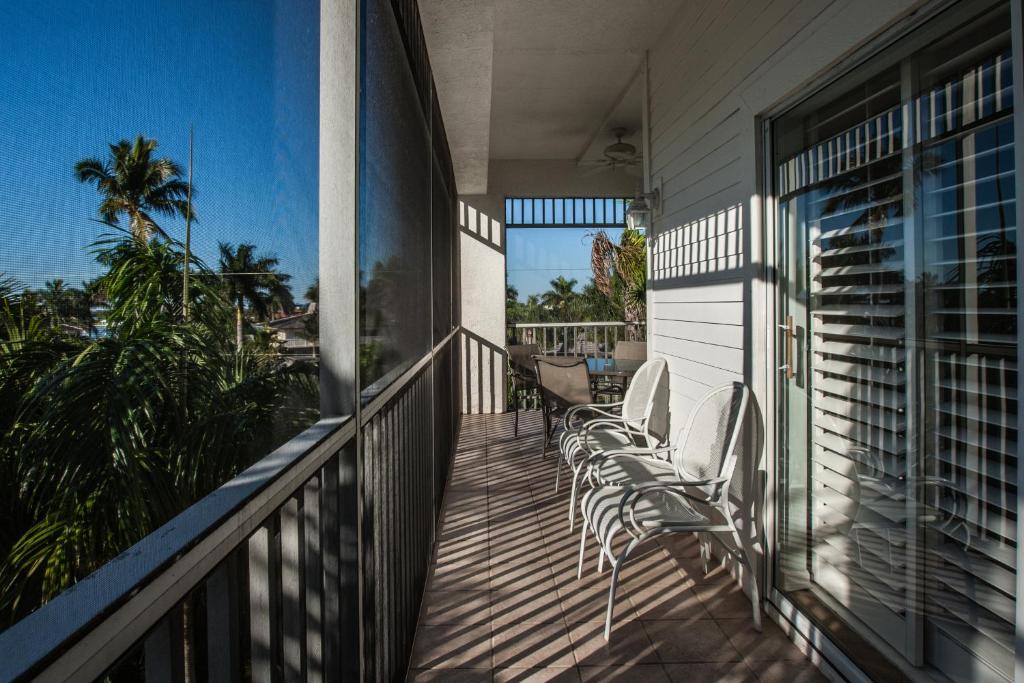 a balcony with chairs and a view of the ocean at Olde Marco Island Inn and Suites in Marco Island