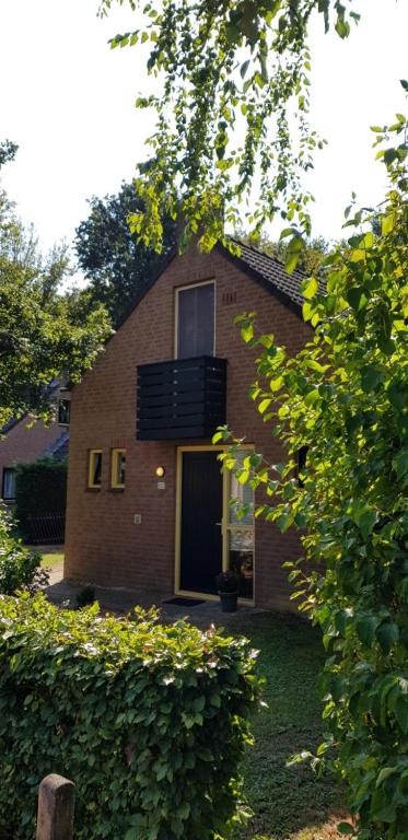 een stenen huis met een raam en een balkon bij Vakantiewoning Maas en Waal in Ewijk