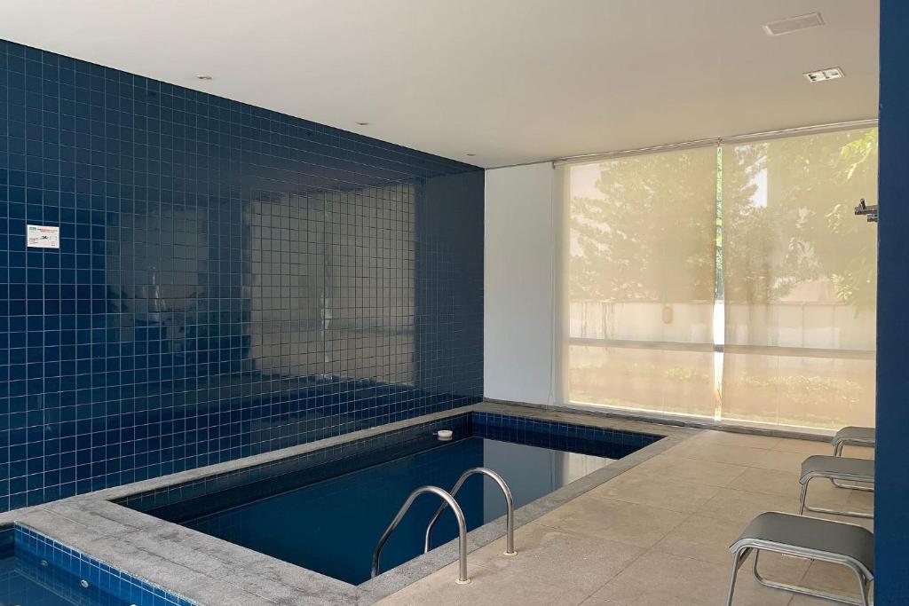 ein Badezimmer mit einem Pool mit blauen Fliesen in der Unterkunft Locking's Santo Agostinho 8 in Belo Horizonte