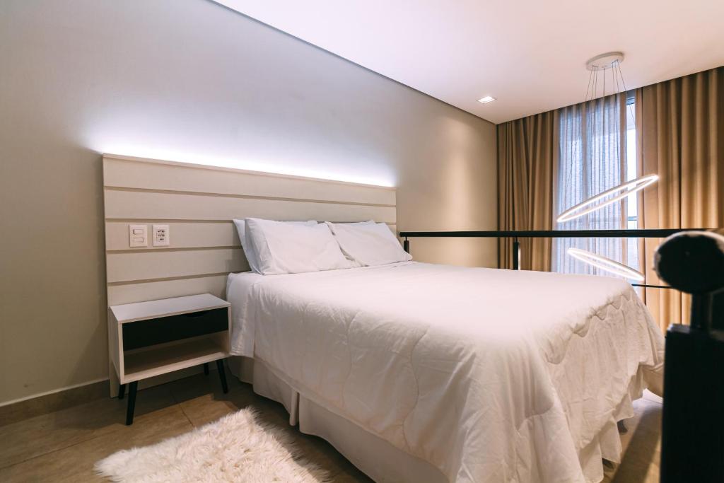 una camera con un letto bianco e una finestra di Multihouse - Moderno Duplex Berrini - WTC - Brooklin a San Paolo