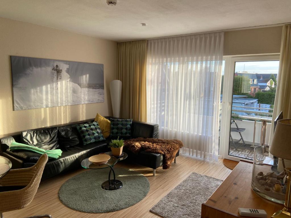 ein Wohnzimmer mit einem Sofa und einem Tisch in der Unterkunft Ferienwohnung Witthöhn 8 in Cuxhaven