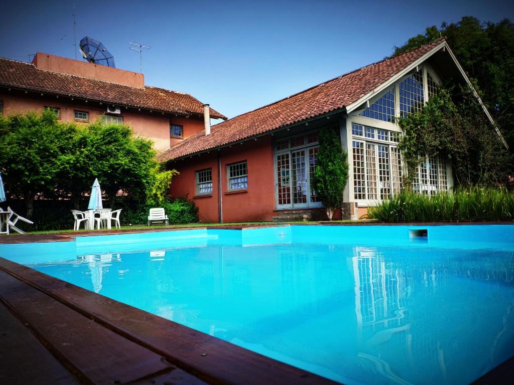 una gran piscina frente a una casa en Pousada Casa Rosa, en Canela