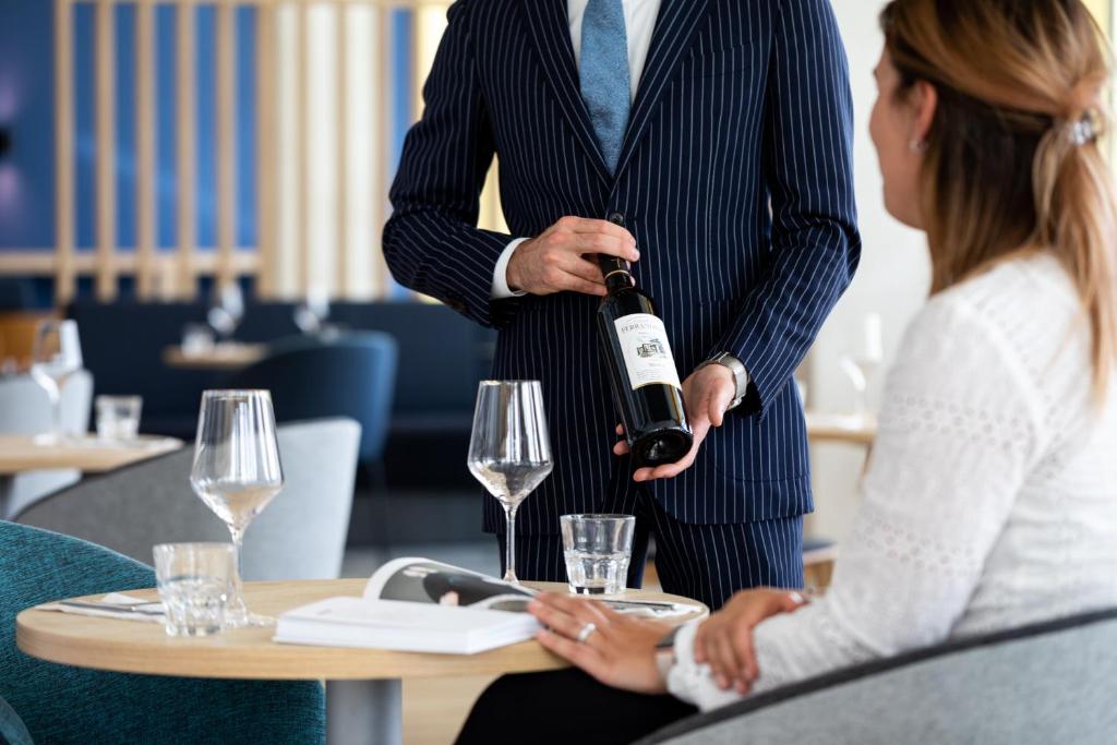 a man holding a bottle of wine next to a woman at Holiday Inn Express Amsterdam - North Riverside by IHG in Amsterdam