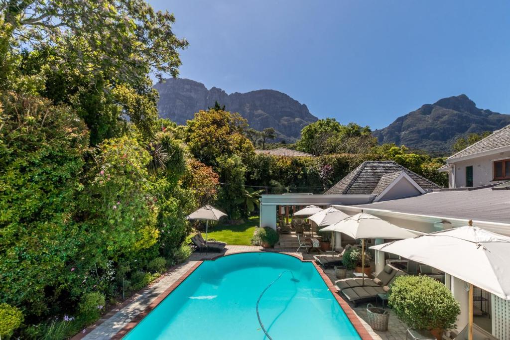 een uitzicht over een zwembad met parasols bij Fernwood Manor Boutique Guest House in Kaapstad