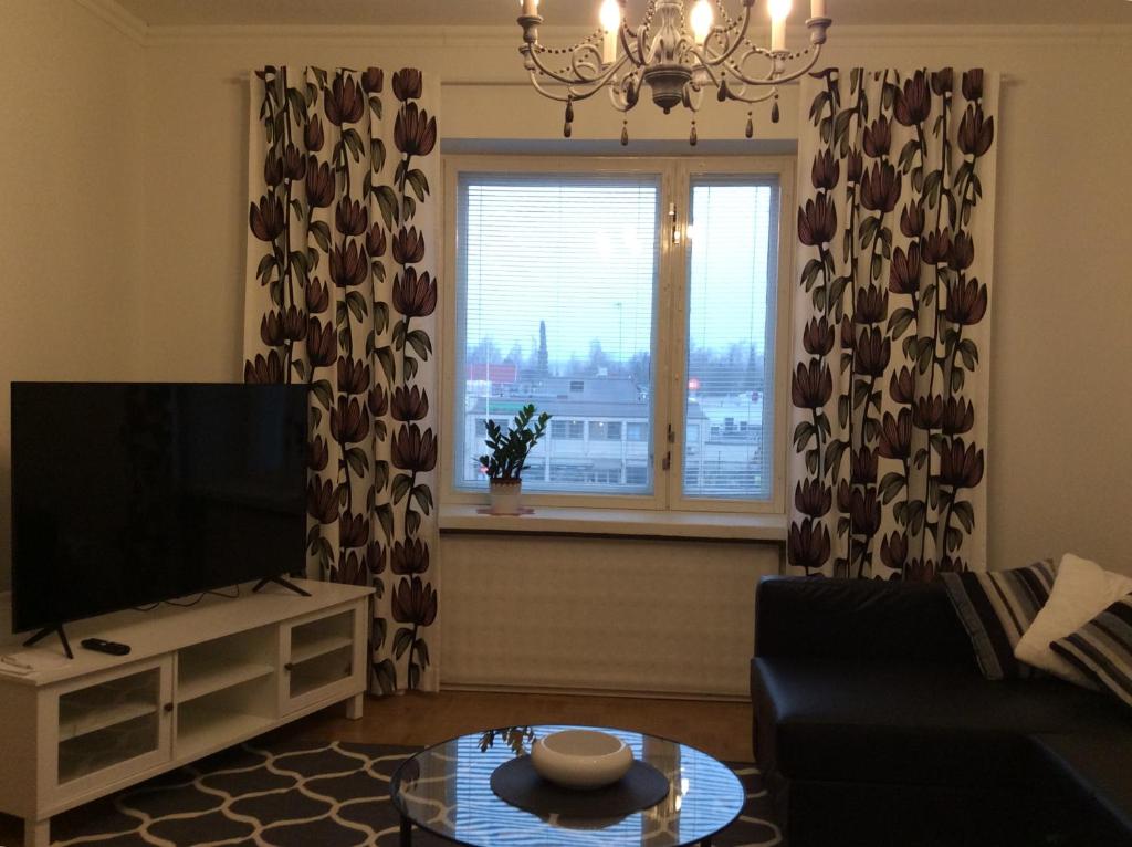 een woonkamer met een televisie en een raam bij Viihtyisä asunto keskustassa palvelujen lähellä in Heinola