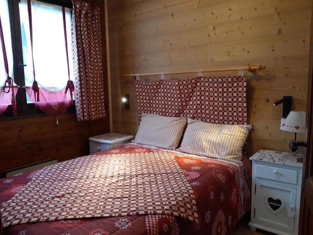 1 dormitorio con 1 cama en una habitación de madera en Triolet, en La Chapelle-dʼAbondance