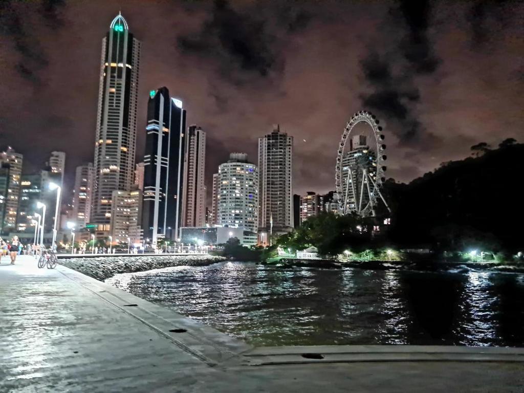 un perfil urbano por la noche con un río y edificios en Apartamento na Av Atlantica com Ar Condicionado, en Balneário Camboriú