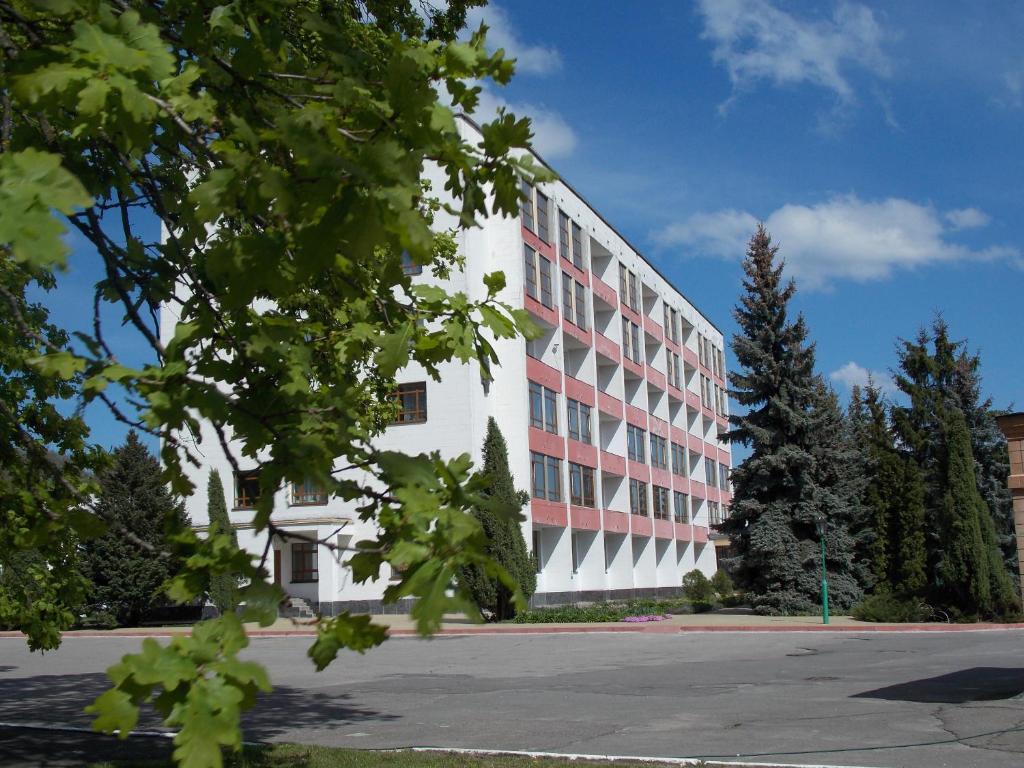 a white and red building with a parking lot at Dibrova in Bila Tserkva