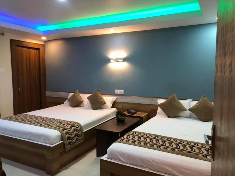 a hotel room with two beds and a blue wall at Yara Hotel in Itahari