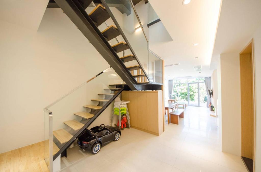 a house with a small car under the stairs at 墾丁山風足跡 in Kenting