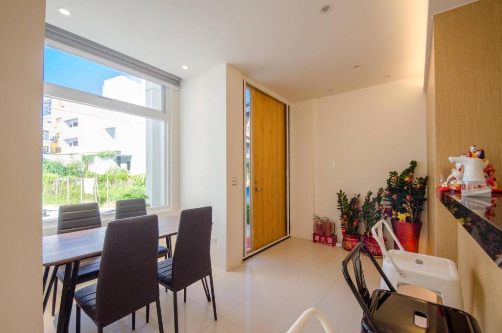 a dining room with a table and chairs and a window at 墾丁山風足跡 in Kenting
