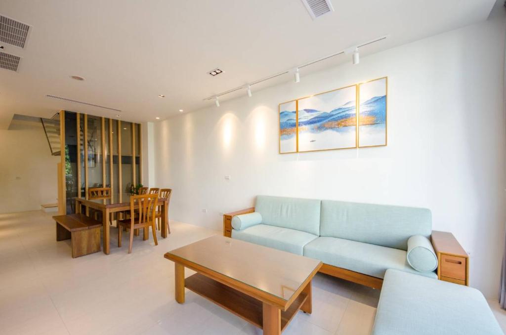 a living room with a blue couch and a table at 墾丁山風足跡 in Kenting