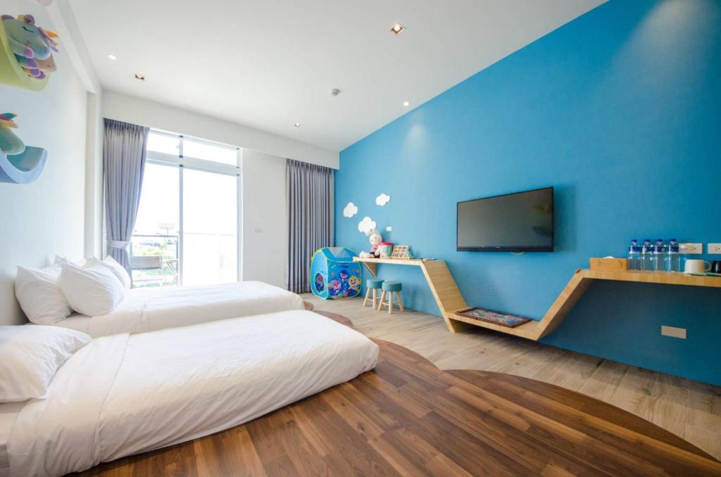 a bedroom with a large bed and a blue wall at 墾丁山風足跡 in Kenting