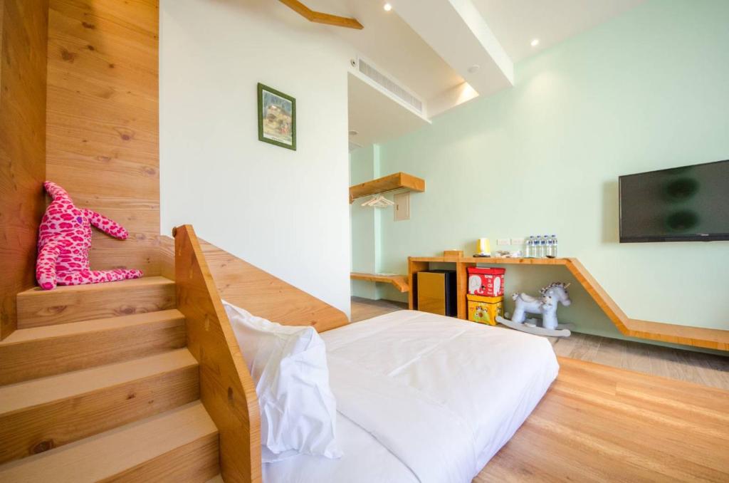 a bedroom with a bed and stairs with a television at 墾丁山風足跡 in Kenting