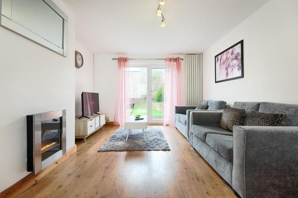 ein Wohnzimmer mit einem Sofa und einem Kamin in der Unterkunft Singleton House Parking & Garden-TV in Every Room! in Swansea