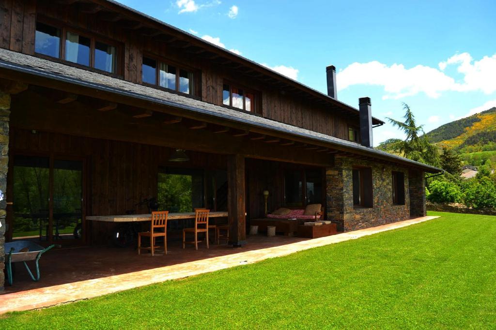 ein Haus mit einer Terrasse mit einem Tisch und Stühlen in der Unterkunft Casa de campo en Nahuja in Nahuja