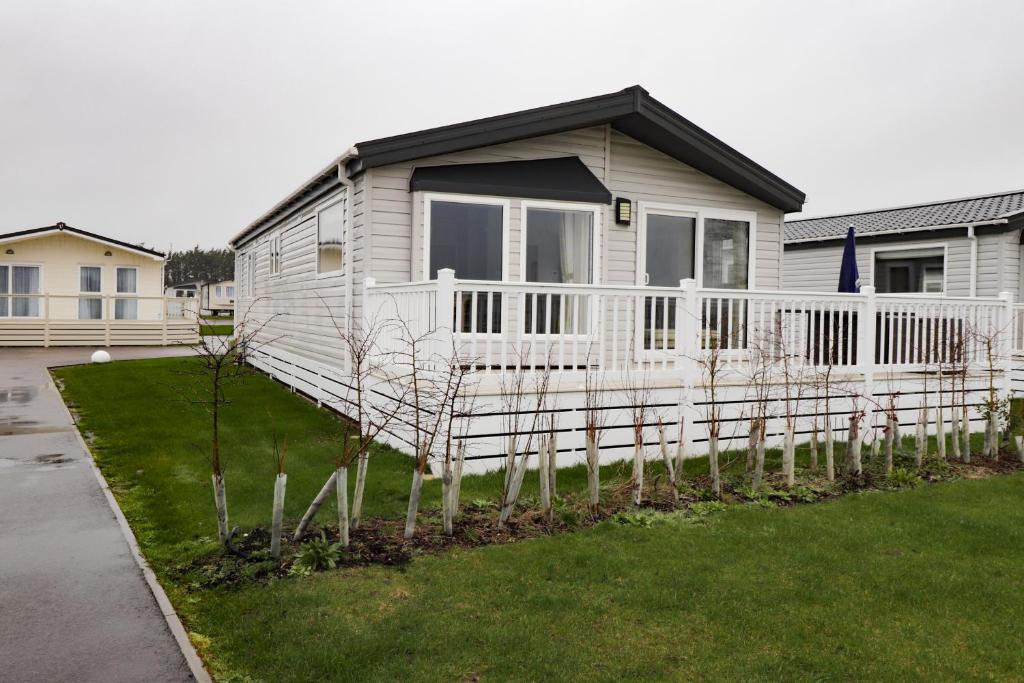 ペバンゼイにある3 bedroom Lodge at Pevensey Bayの白い柵の家