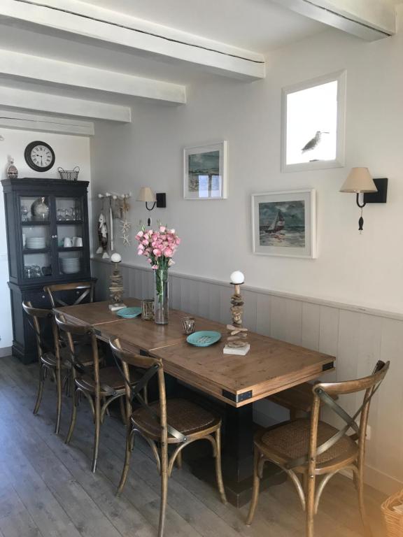 a dining room with a wooden table and chairs at Villa Pigouille in Sainte-Marie-de-Ré