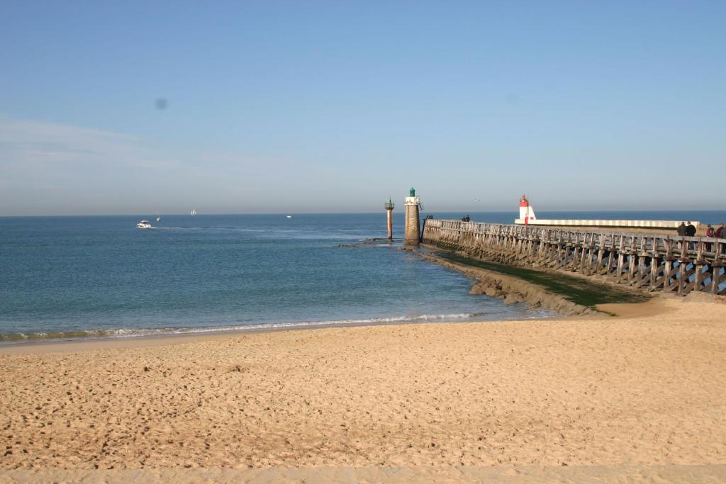 a beach with a pier and a boat in the water at Studio Cap Sud Capbreton proche plage in Capbreton