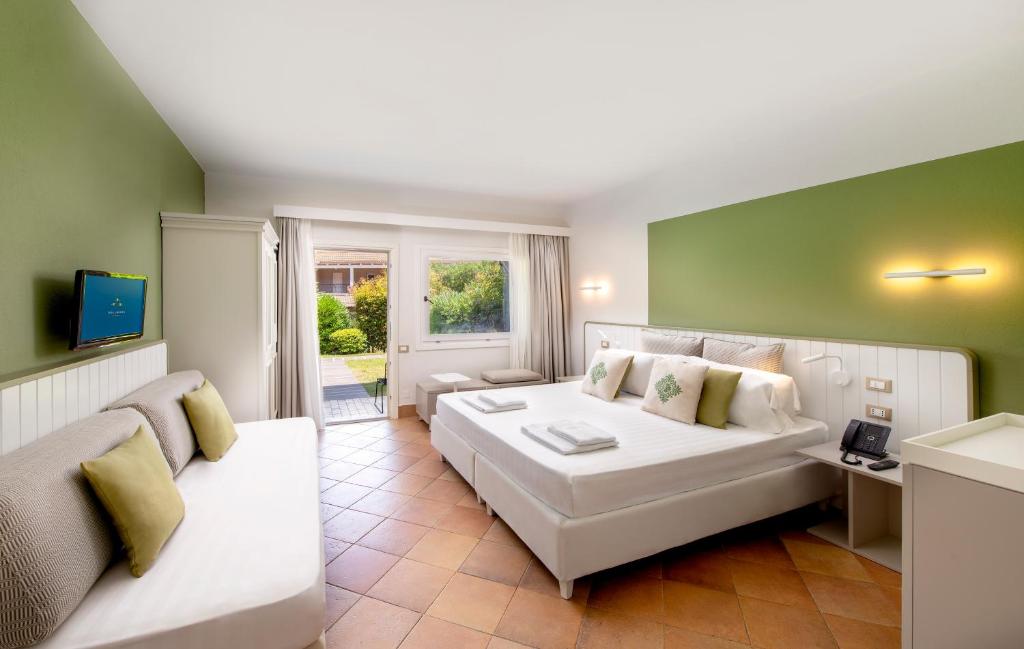 a living room with a white couch and a television at Chia Laguna - Hotel Village in Chia