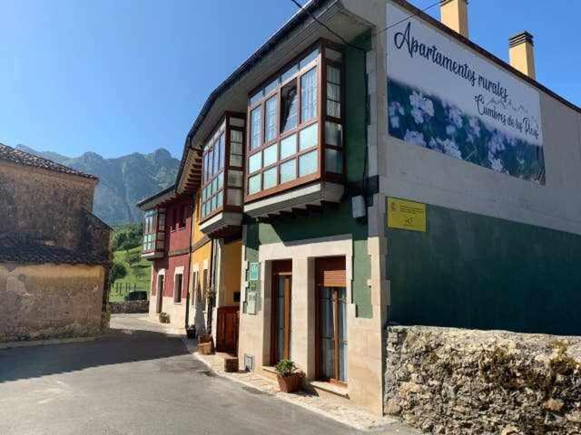 a building with a sign on the side of it at Cumbres de los Picos Apartamento Treparriscos in Poo de Cabrales