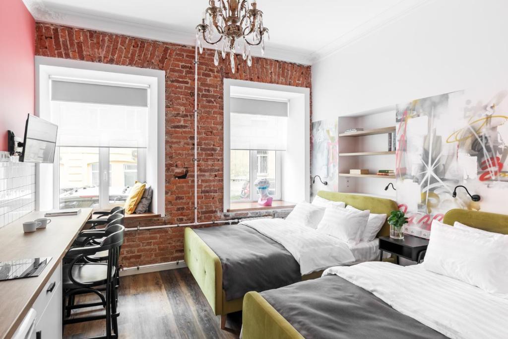 a bedroom with two beds and a brick wall at Z17 Apartments in Saint Petersburg