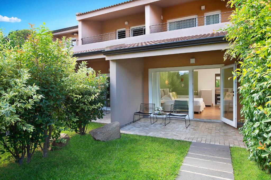 a view of a house with a patio and a garden at Chia Laguna - Hotel Village in Chia