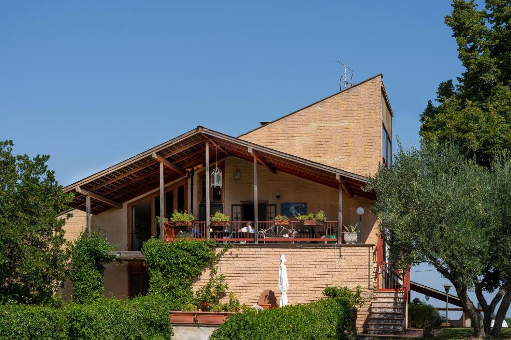 een stenen huis met een veranda en een balkon bij Villa dei Gelsomini, Residenza nel verde in Viterbo
