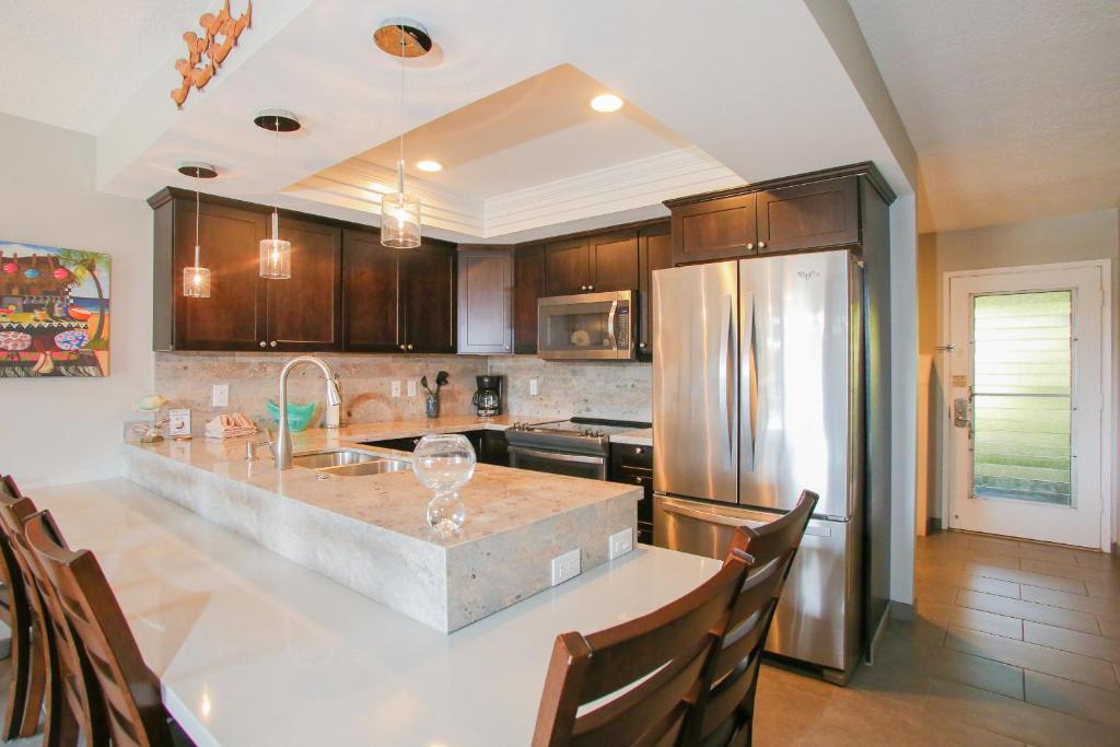 a kitchen with a counter and a refrigerator at Kahana Sunset #B7 Home in Kahana