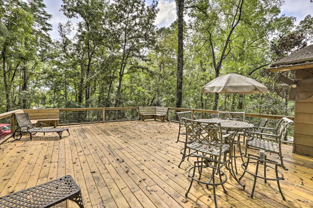 een terras met een tafel en stoelen en een parasol bij Charming Tallahassee Family Hideaway 5 Mi to FSU! in Tallahassee