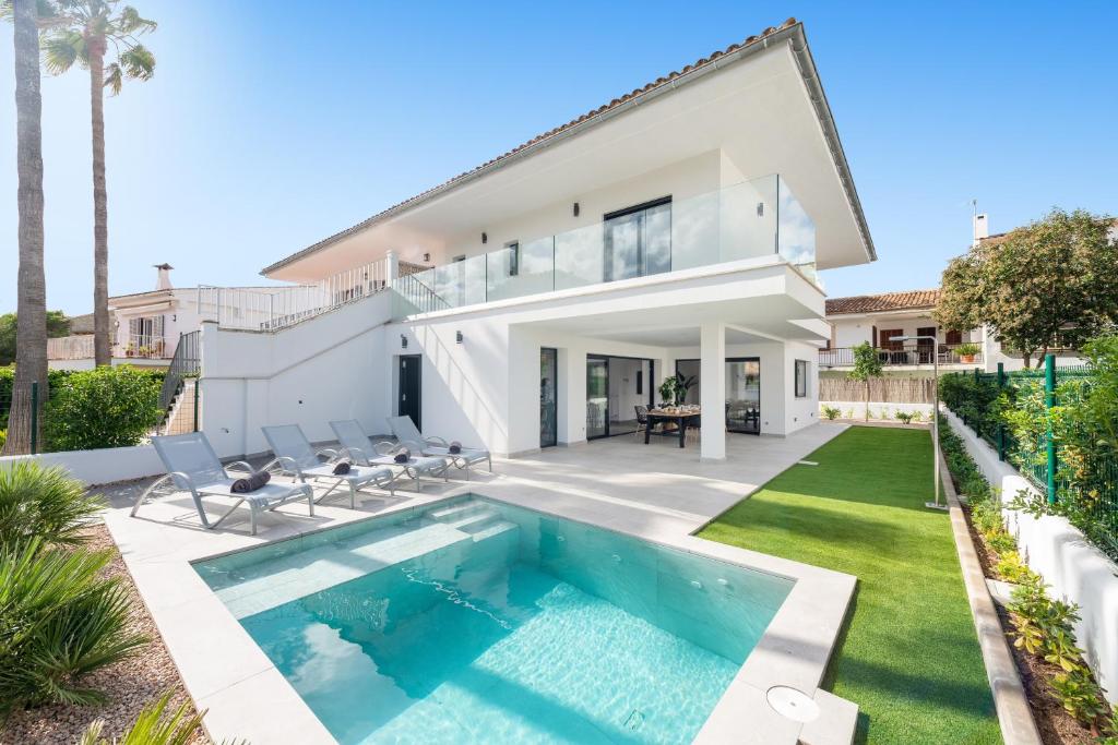 a villa with a swimming pool and a house at Ca na Cati (Barcarés) in Alcudia