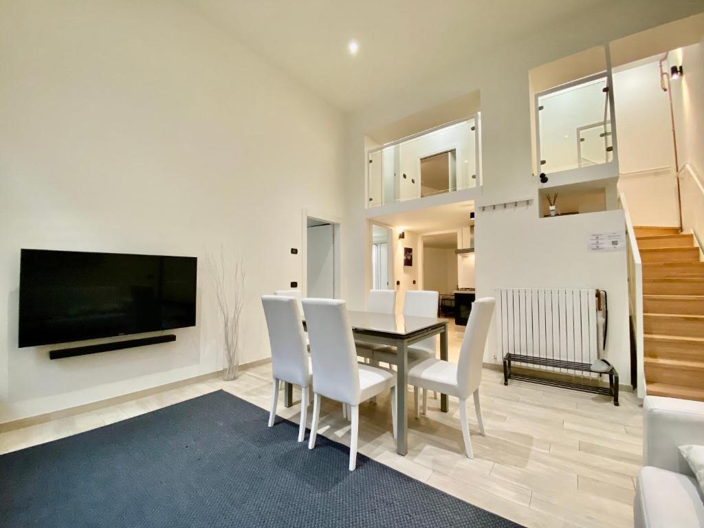 a dining room with a table and chairs and a tv at Future Apartments in Milan