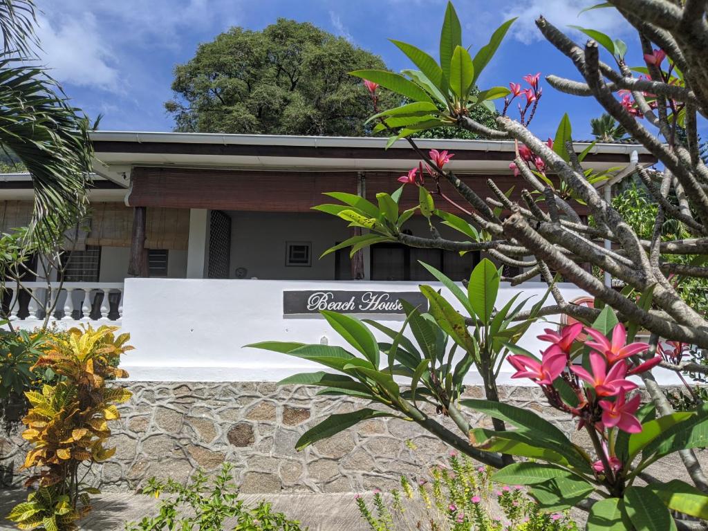 a house with a sign in front of it at The Beach House in Beau Vallon