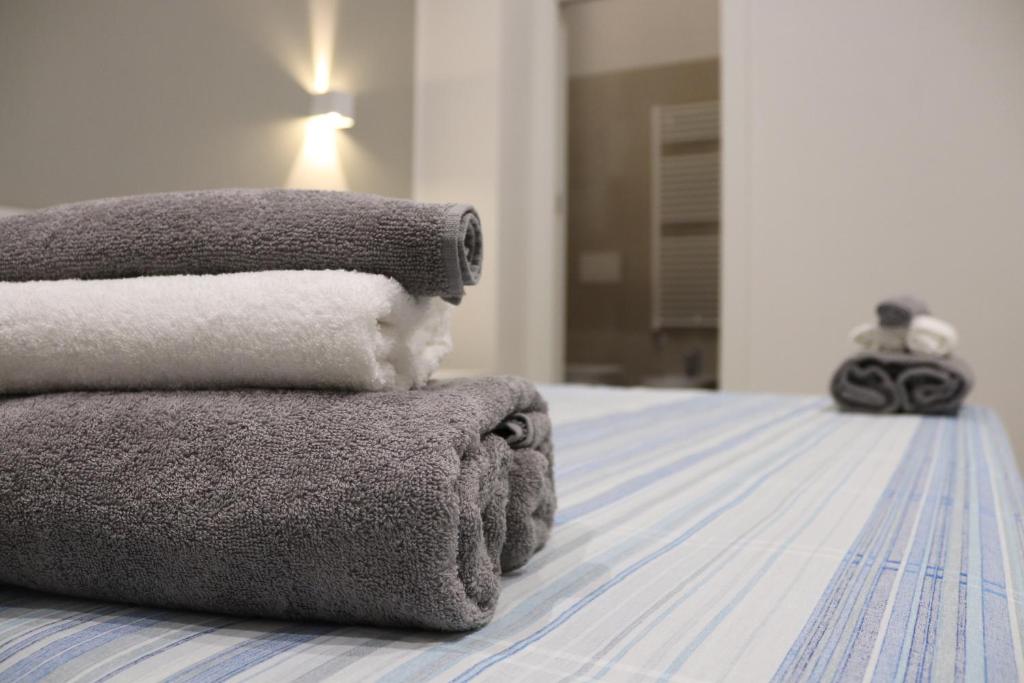 una pila de toallas sentadas encima de una cama en Moon Bologna, en Bolonia