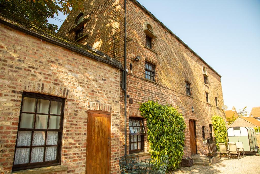 a brick building with a wooden door on it at Apartment Two, The Carriage House, Bilbrough, York in York