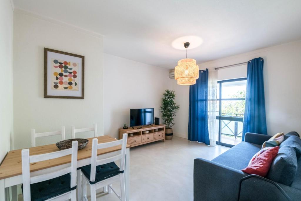 a living room with a blue couch and a table at Casa do Moinho da Praia in Altura