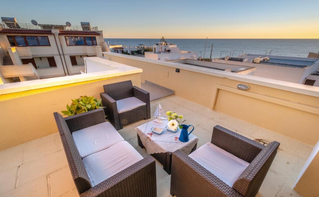 a balcony with a table and chairs and the ocean at Living Room in Leuca in Leuca