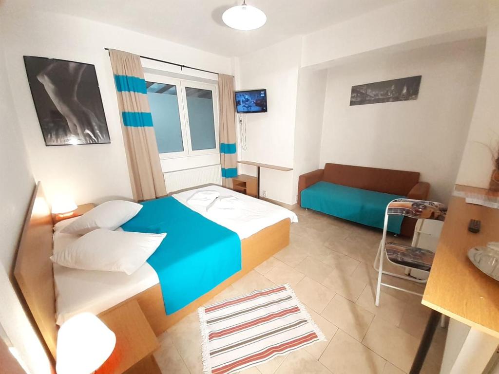 Cette petite chambre comprend un lit et un canapé. dans l'établissement Taxi Hostel, à Otopeni