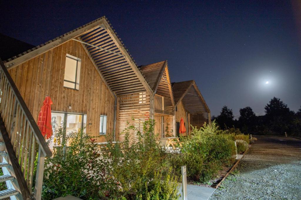 une maison la nuit avec la lune dans le ciel dans l'établissement Le jardin des 4 saisons, au Mans