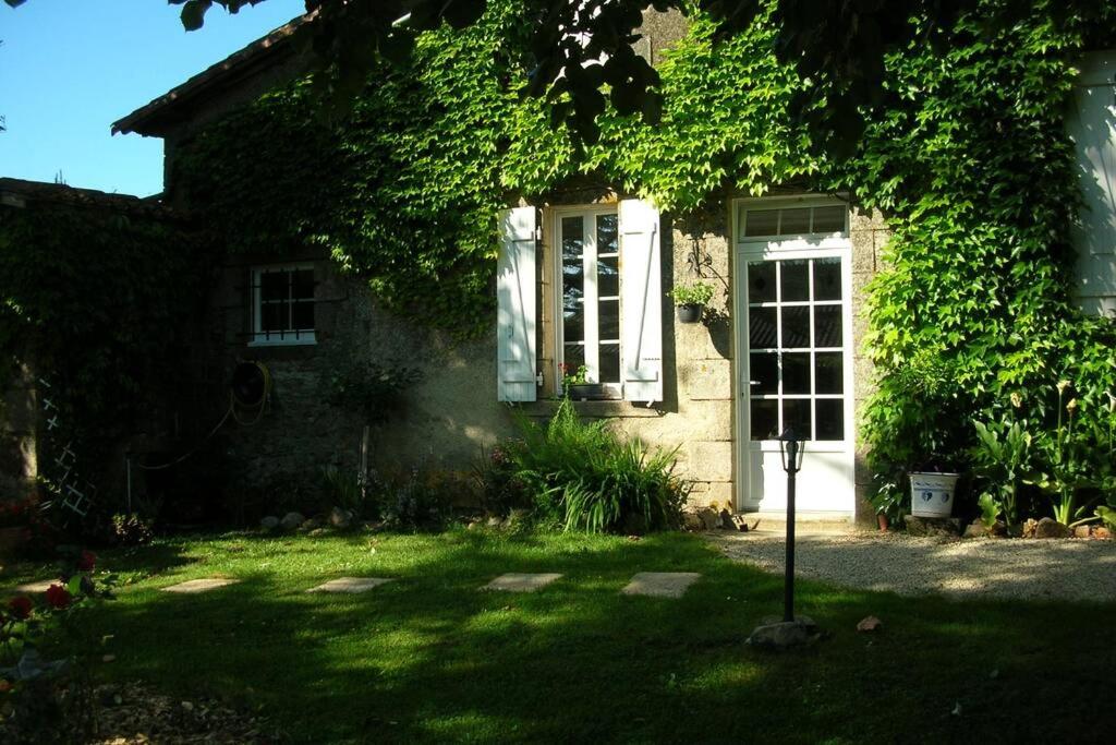 une maison en briques avec une fenêtre et du lierre dans l'établissement Gîte de La Ribotière à 15 min du Puy du Fou, à Pouzauges