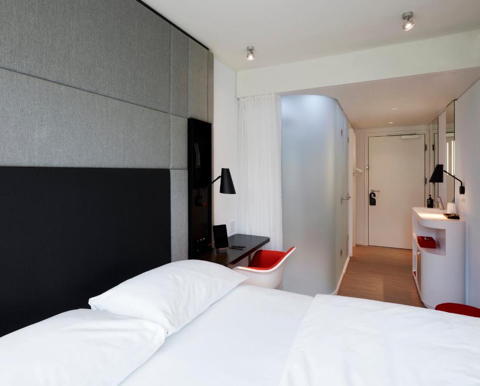 ein Schlafzimmer mit einem großen weißen Bett und einem Schreibtisch in der Unterkunft citizenM Seattle South Lake Union in Seattle