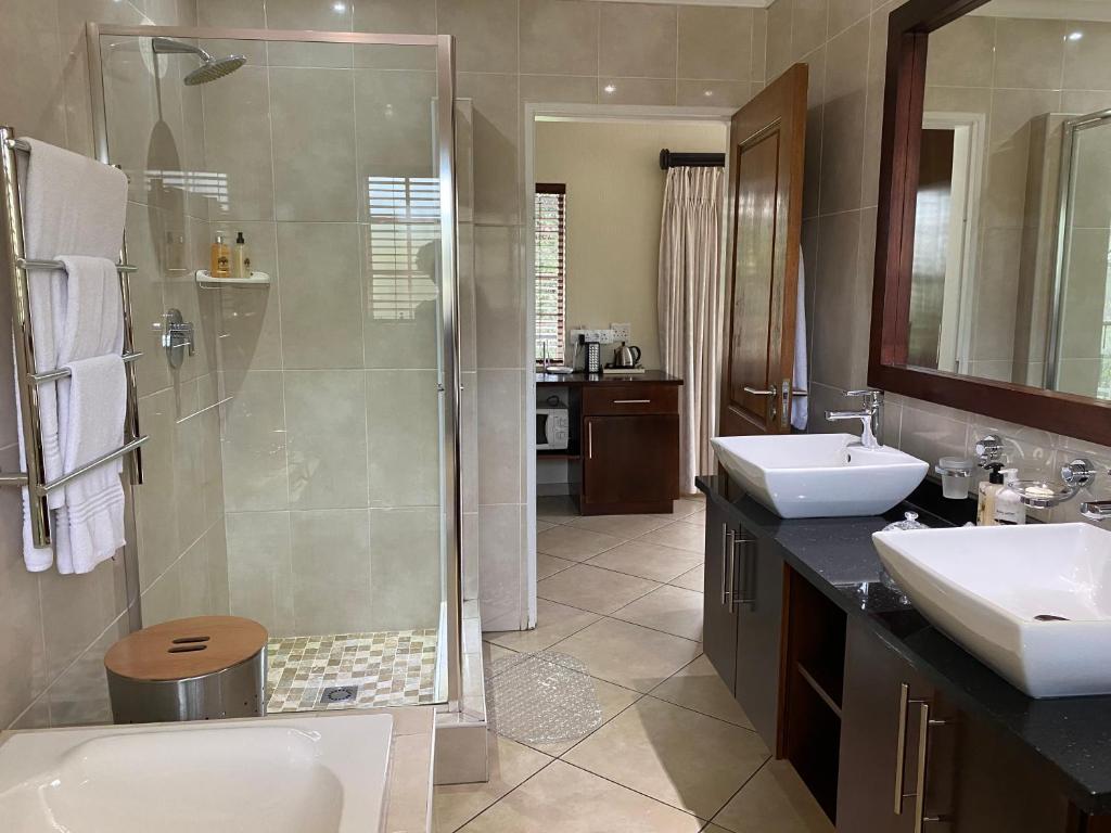 a bathroom with a shower and a sink and a toilet at Gallo Manor Executive Bed & Breakfast in Johannesburg