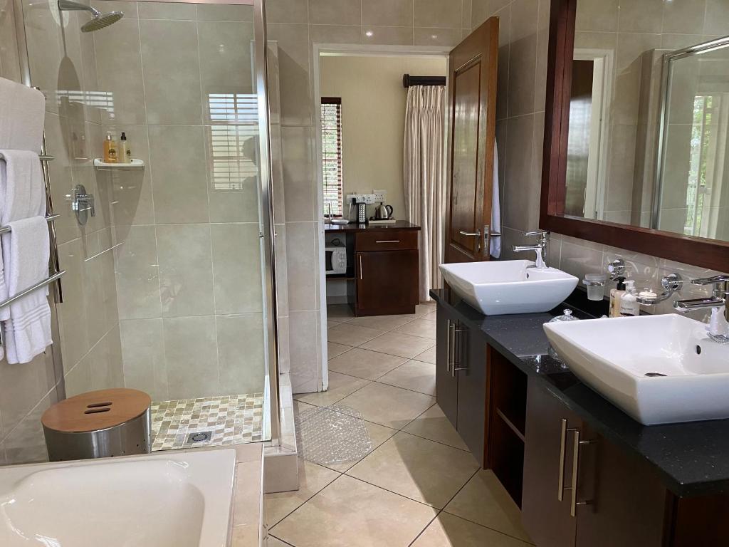 a bathroom with a shower and a sink and a toilet at Gallo Manor Executive Bed & Breakfast in Johannesburg