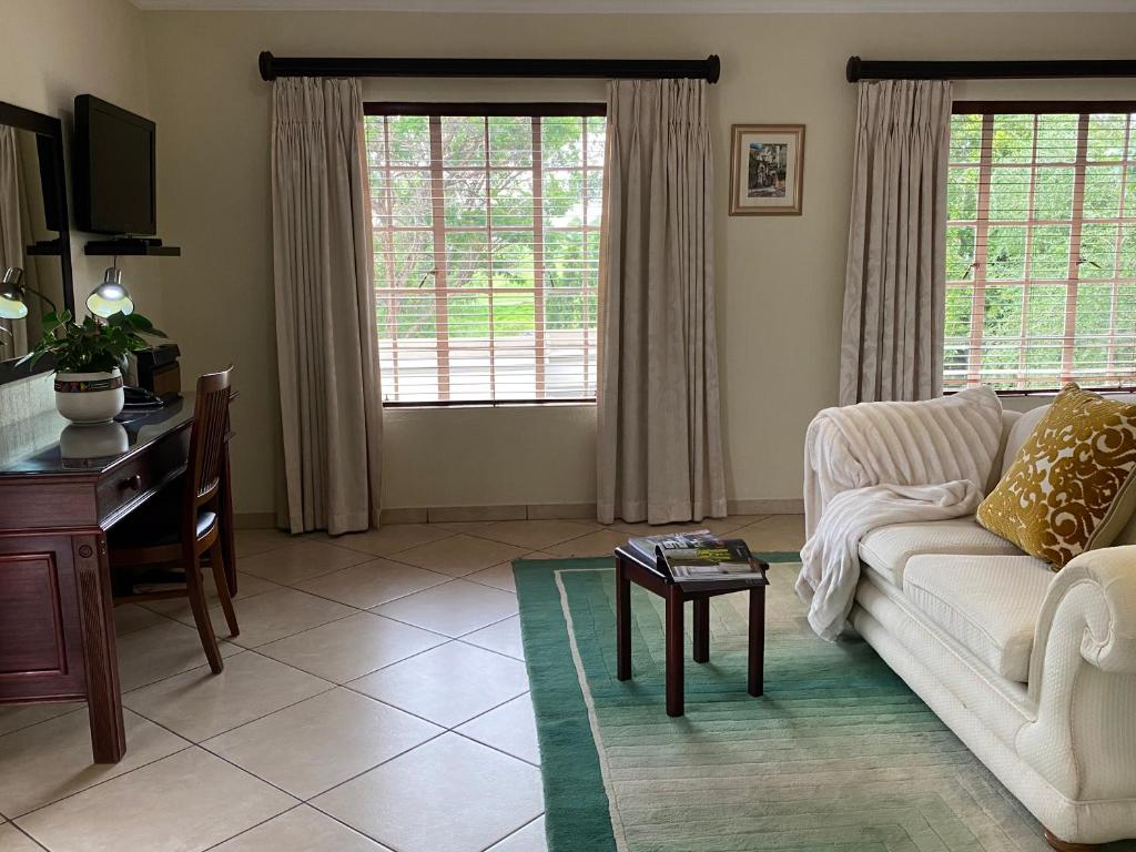 a living room with a couch and a table at Gallo Manor Executive Bed & Breakfast in Johannesburg