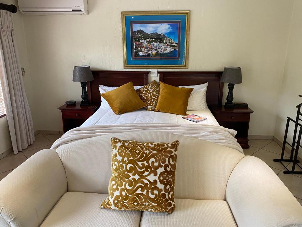 a bedroom with a large bed and a couch at Gallo Manor Executive Bed & Breakfast in Johannesburg