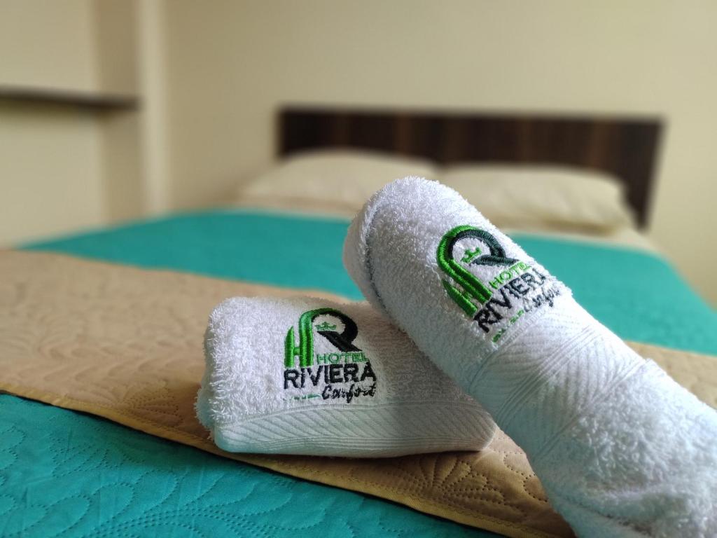 two rolled towels sitting on top of a bed at Hotel Riviera Confort in Pasto