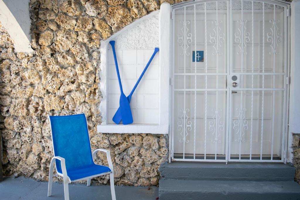 una silla azul sentada frente a una pared con un reloj en Private Studio in Shenandoah - 4K, en Miami