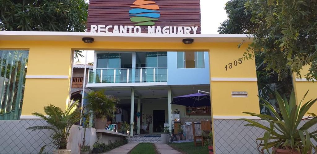 ein gelbes Gebäude mit einem Schild darüber in der Unterkunft Pousada Recanto Maguary in Alter do Chao